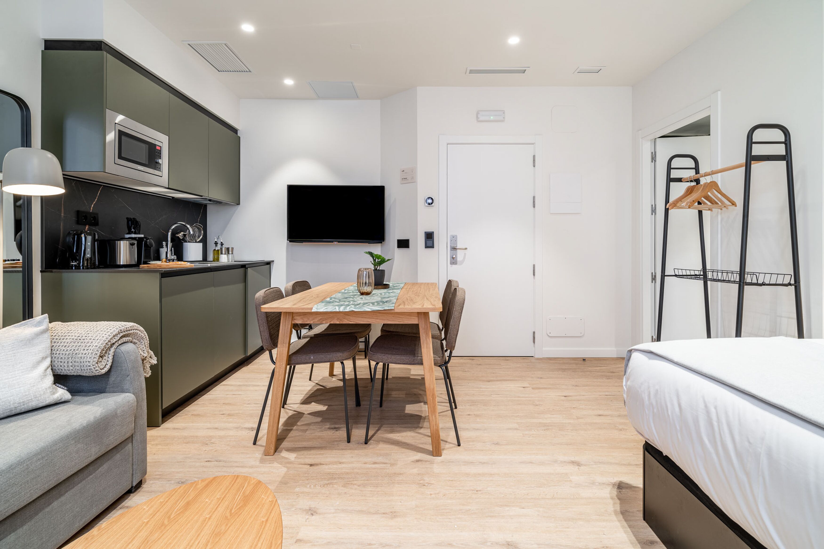 Un espacio habitable compacto con kitchenette, comedor y dormitorio.