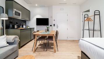 Un espacio habitable compacto con kitchenette, comedor y dormitorio.