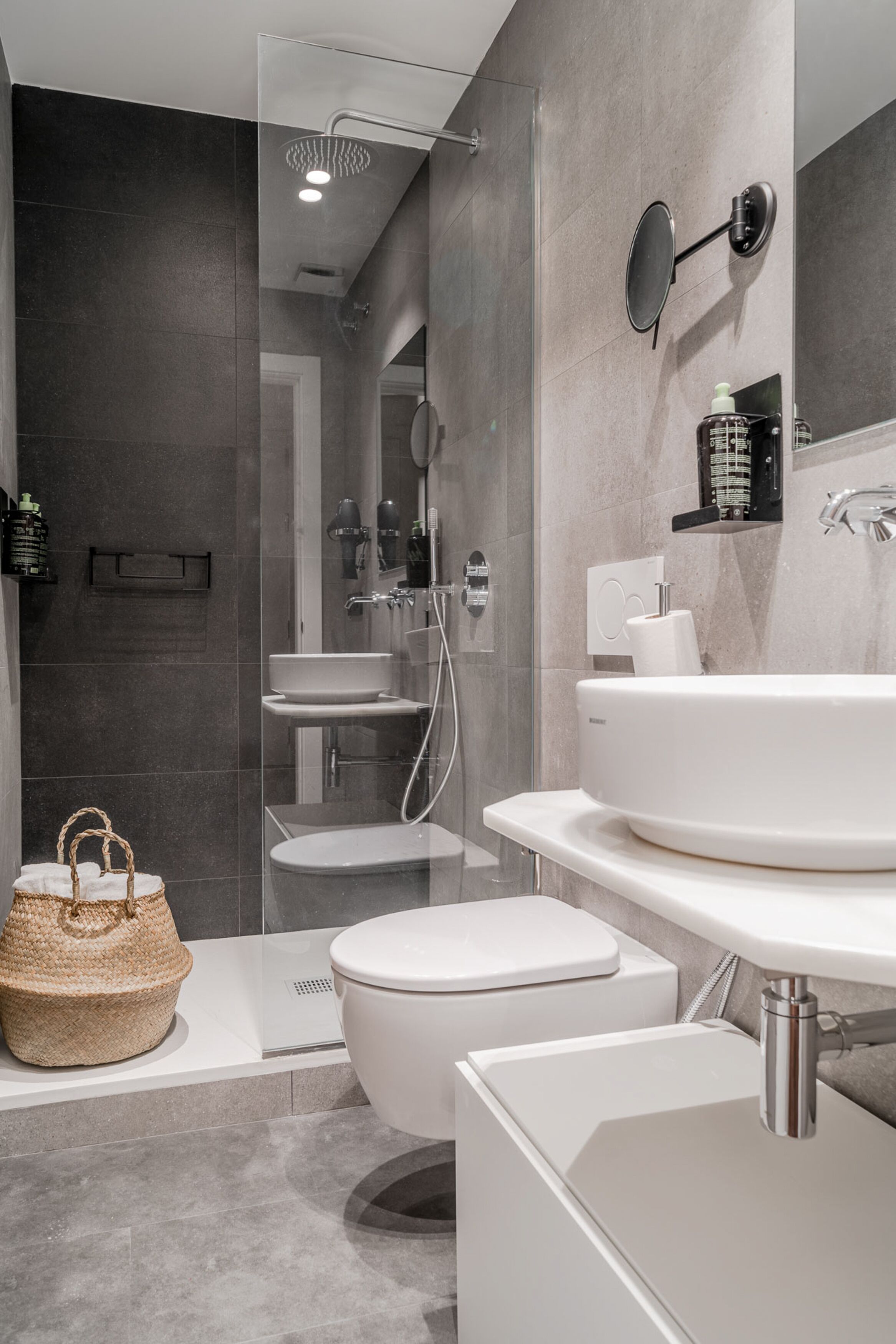 A modern bathroom with a large bathtub, a separate toilet, and a glass-enclosed shower area.