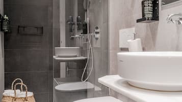 A modern bathroom with a large bathtub, a separate toilet, and a glass-enclosed shower area.