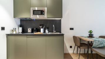 Eine moderne Küche mit Einbau-Mikrowelle, Kaffeemaschine und Spüle.