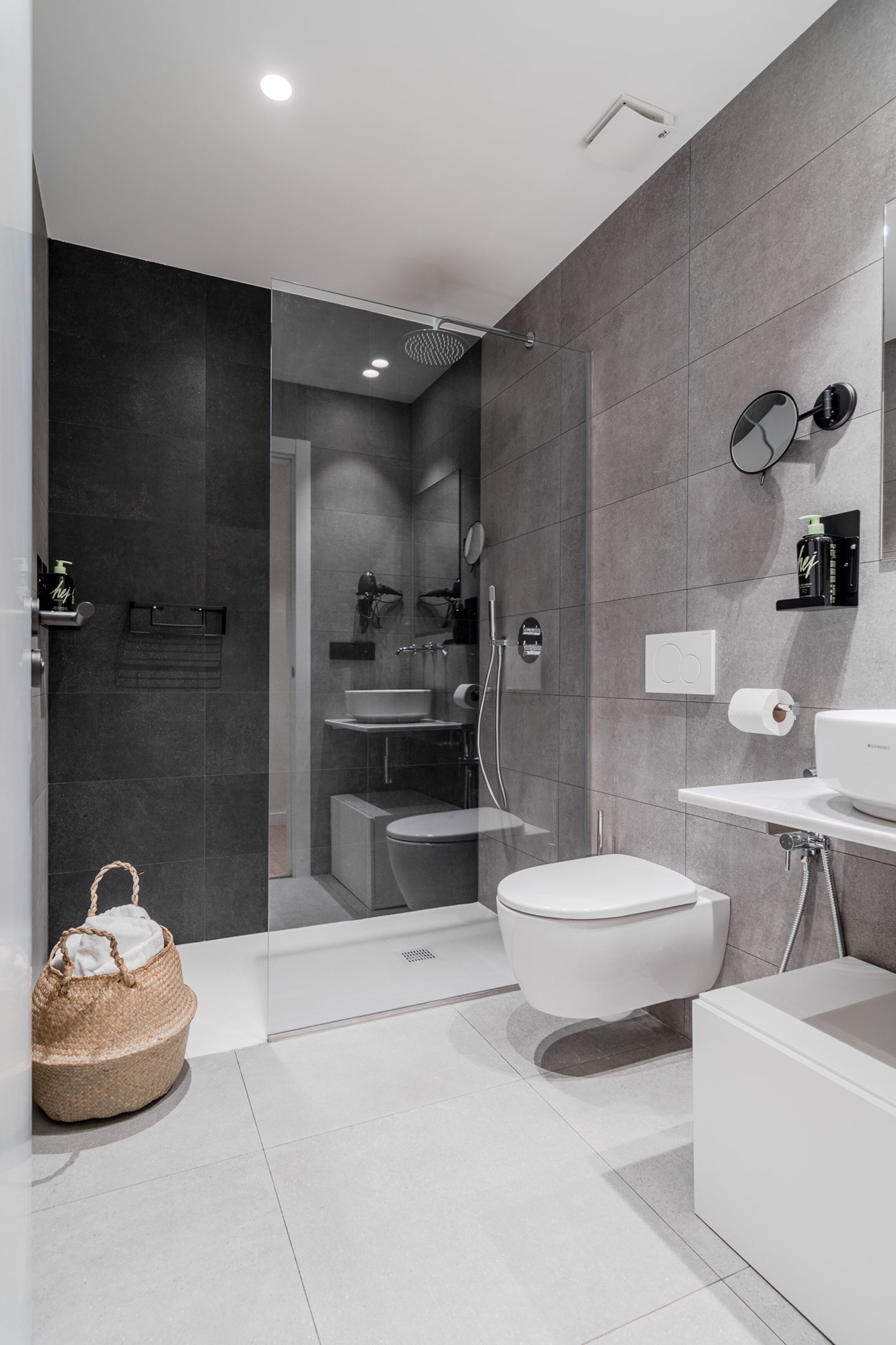 Un baño moderno con ducha envuelta en vidrio, inodoro, lavamanos y bañera.