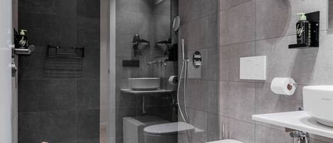 Un baño moderno con ducha envuelta en vidrio, inodoro, lavamanos y bañera.