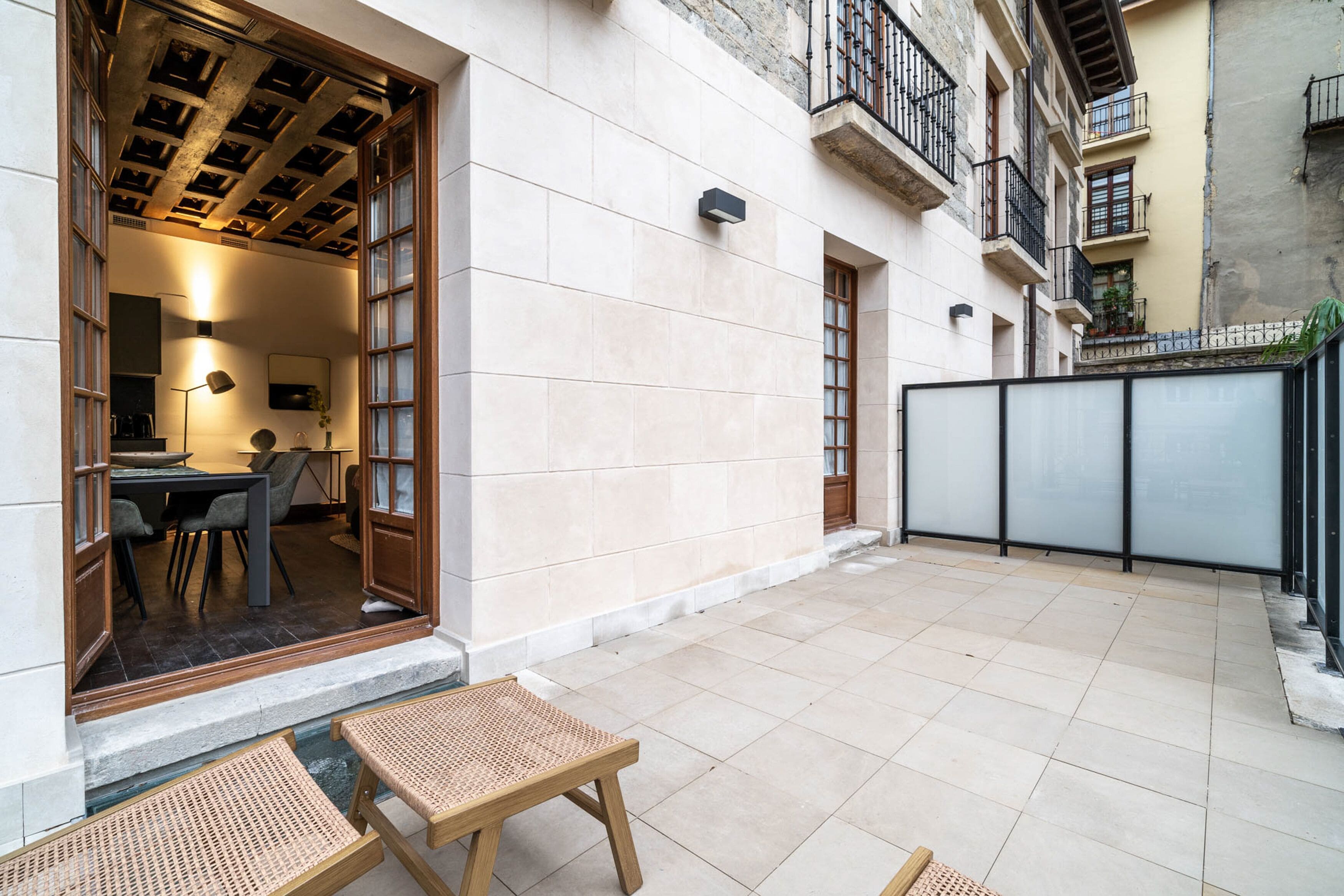 A courtyard with a dining area, a small table, and a bench.