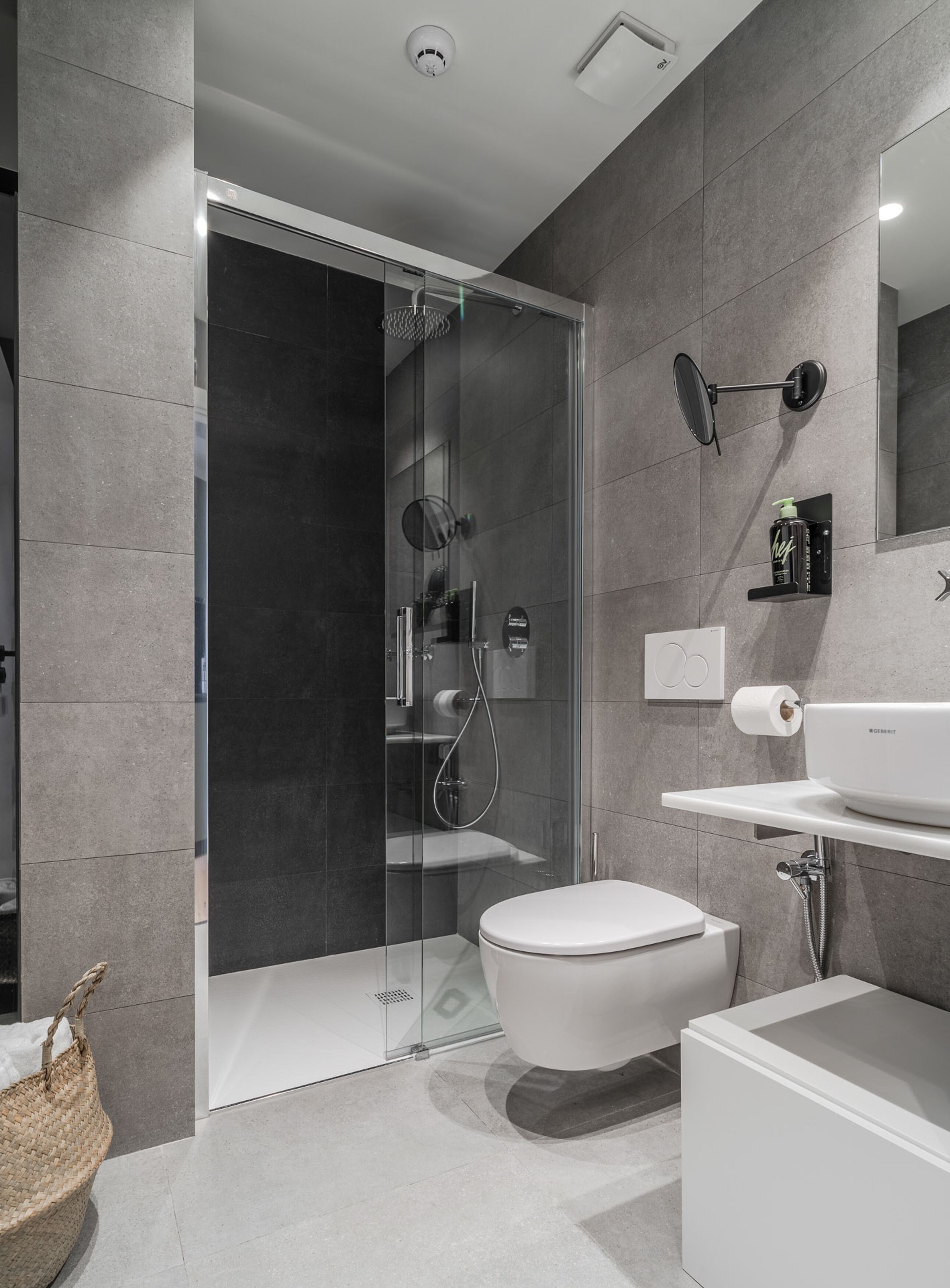 Un baño moderno con ducha de vidrio, inodoro y lavamanos.