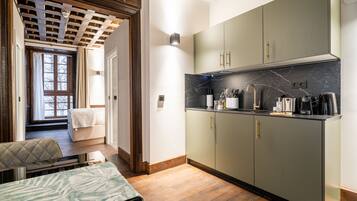 A modern kitchen with marble countertops, built-in cabinets, and a dining area with a table and bench.