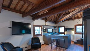 Une cuisine moderne avec un plafond en bois, un grand téléviseur et un coin bar.