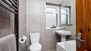 Un bagno con un water, un lavandino e una vasca da bagno.
