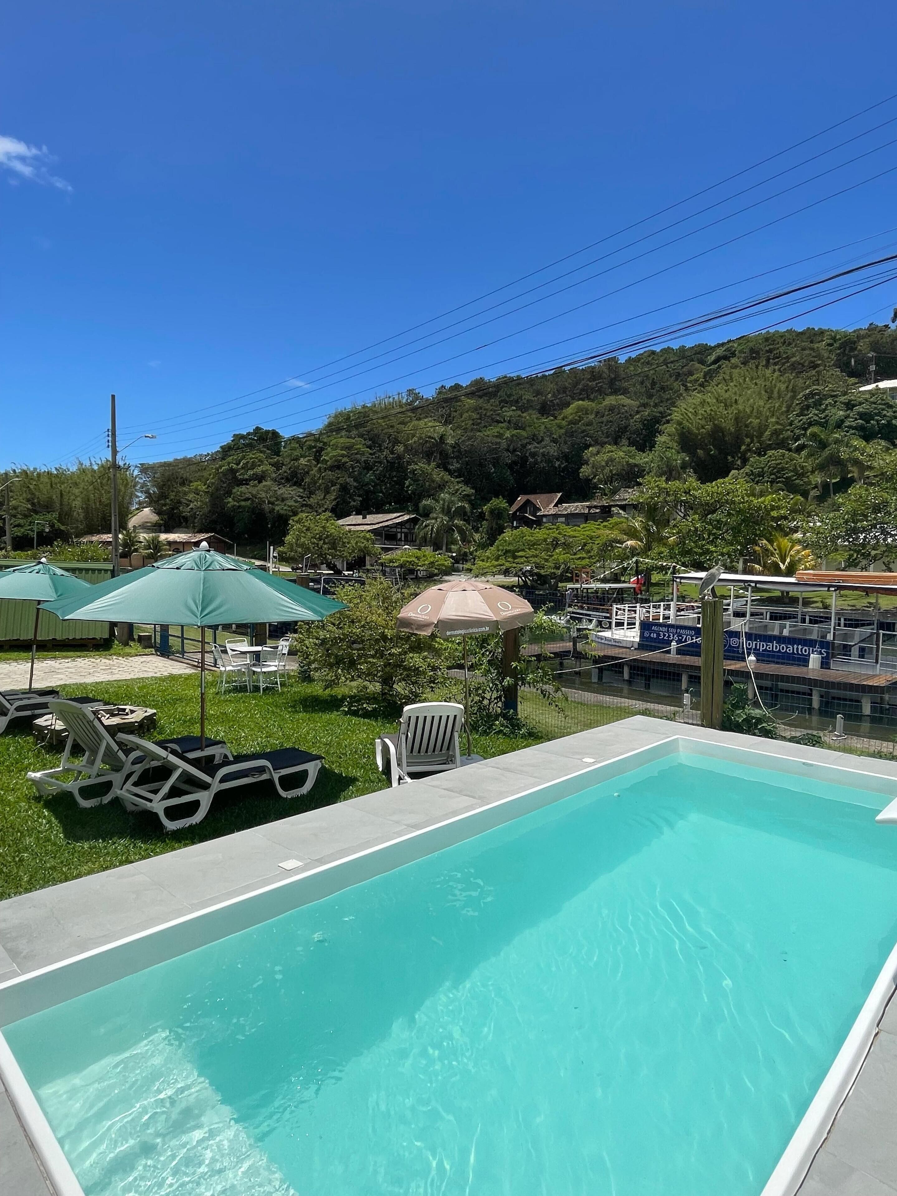 Una piscina al aire libre, sillones reclinables de piscina