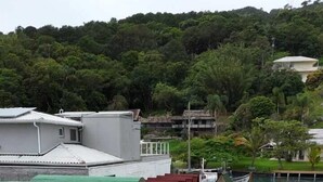 Une rangée de cabanes en bois aux toits verts, disposées sur une zone pavée avec des carreaux hexagonaux.