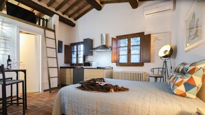 A bedroom with a bed, a desk, a chair, a radiator, a window, and a lamp. - Cammino Santo - studio w/private pool & garden (Poggibonsi)
