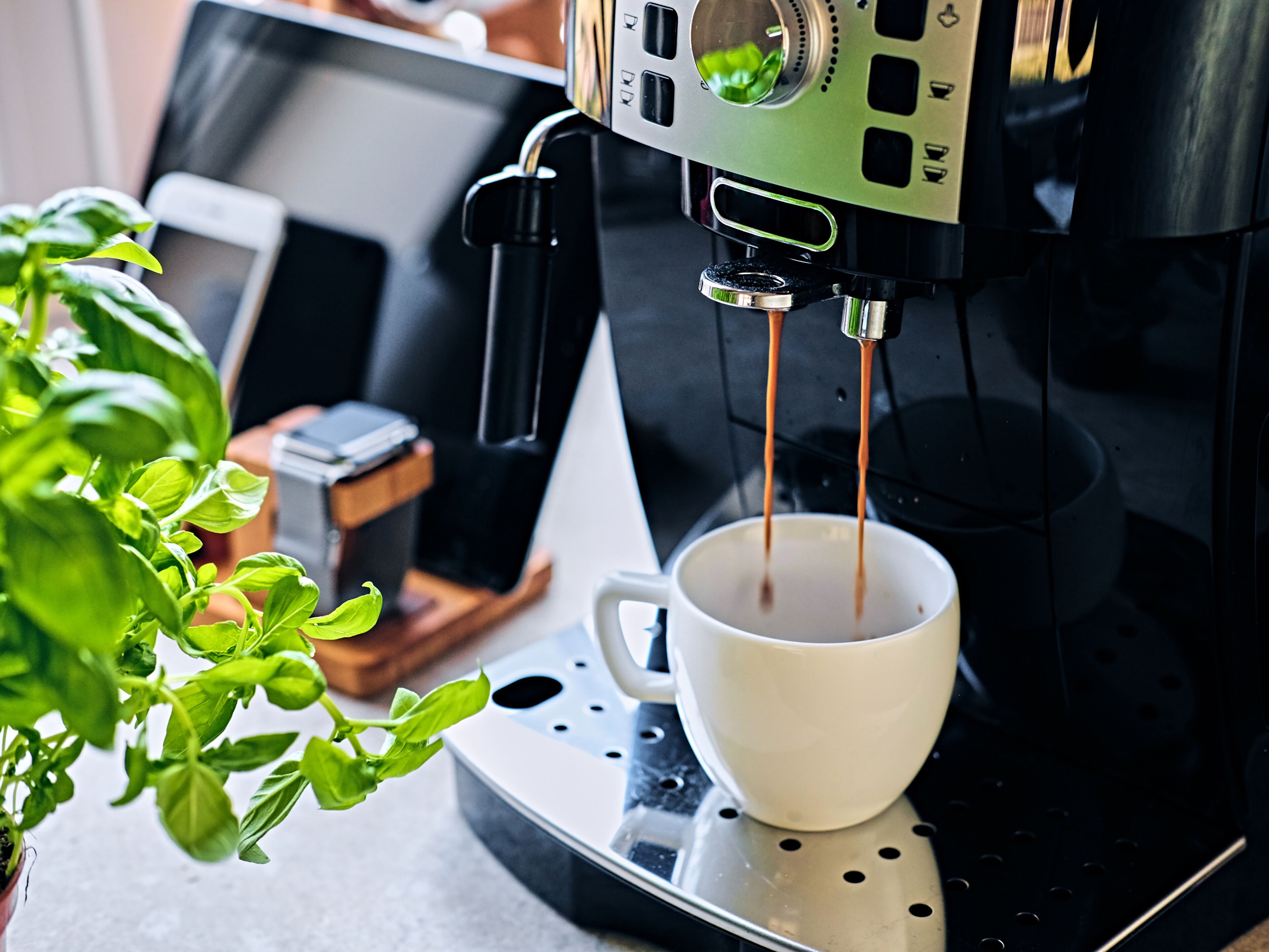 Een koffieapparaat schenkt koffie in een kop.