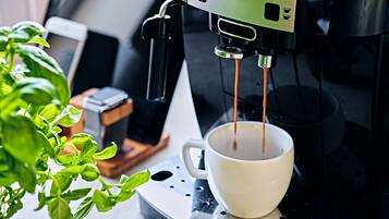 Een koffieapparaat schenkt koffie in een kop.