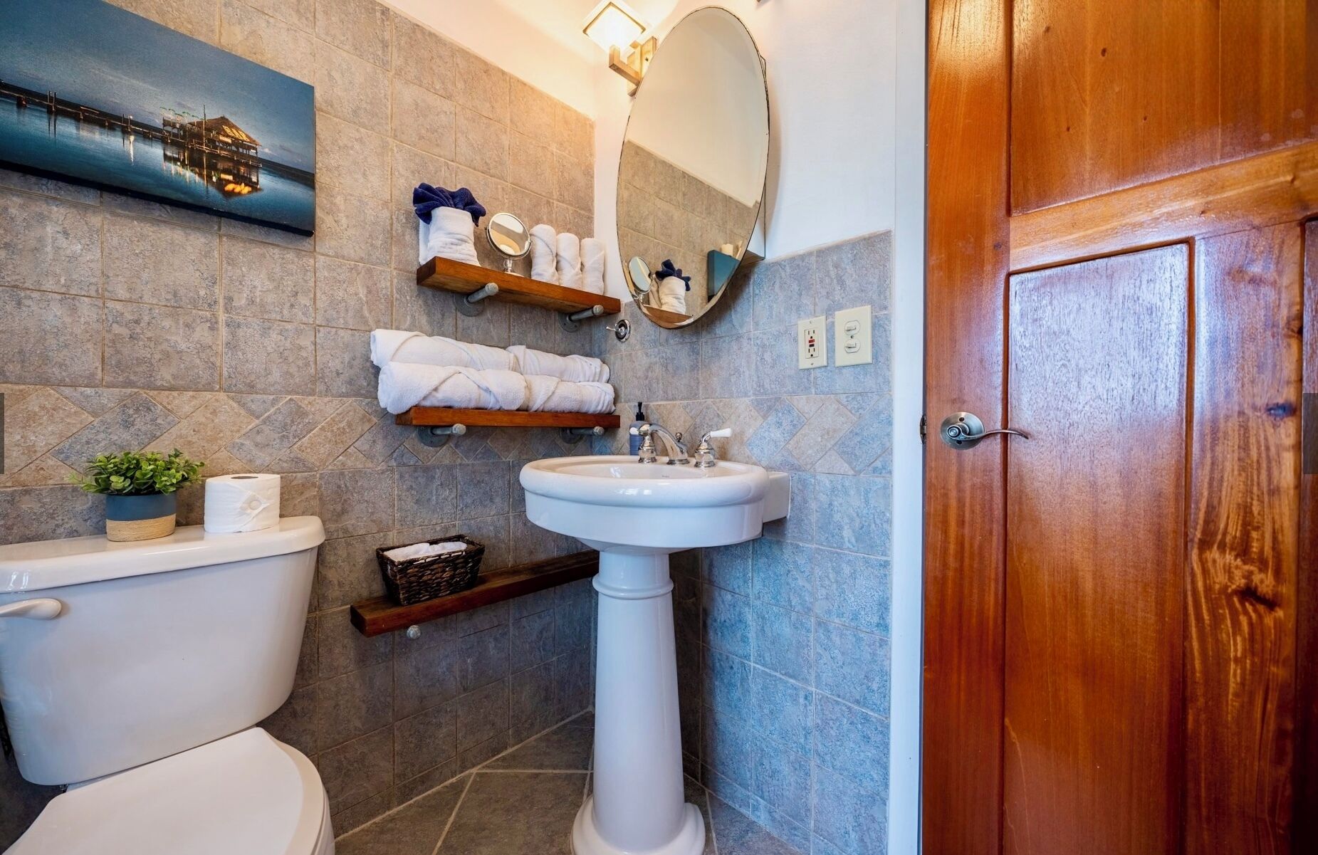 Ein Badezimmer mit Toilette, Waschbecken und Holztür.