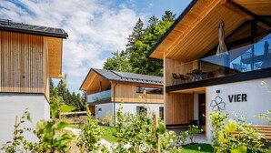 A modern building with a wooden facade, a glass entrance, and a sign reading "VIER". - Pfänder Glück (Lochau)