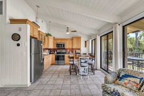 A spacious kitchen with wooden cabinets, a stainless steel refrigerator, and a dining area with a table and chairs.