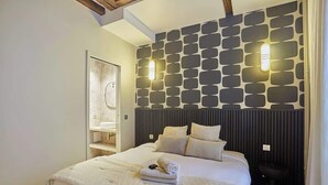 Een moderne slaapkamer met een groot bed, een wandlamp en een ingebouwde plank.