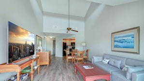 A spacious living room with a wooden coffee table, a grey sofa, and a dining area with wooden chairs. - On the Sea Palms Golf Course. 18th Hole, Fairway and Lagoon frontage (Saint Simons Island)