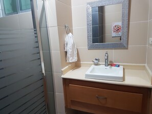 A bathroom with a white sink, a mirror with a decorative frame, and a towel hanging on a rack. - Bello y céntrico (Santiago de los Caballeros)