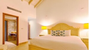 Ein Schlafzimmer mit einem großen Bett, einem Holzkopfende, zwei Nachttischlampen und einem Holzboden.