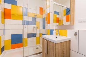 A bathroom with a shower, a sink, and a mirror. - MILESTONE Wrocław Ołbin by Tribera (Wroclaw)