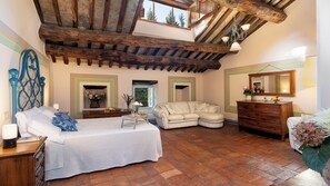 A bedroom with a bed, a sofa, a dresser, and a window. - Villa La Rassinata 12, Emma Villas (Arezzo)