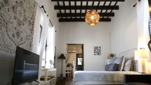 A bedroom with a bed, a TV, a desk, and a chair.