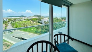 Un balcón con vistas despejadas a un paisaje urbano, que incluye edificios y zonas verdes.