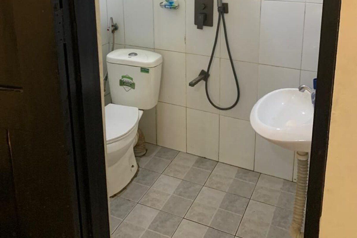 A small bathroom with a toilet, a sink, and a shower.