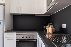 Une cuisine équipée d’une cuisinière, d’un four, d’un four à micro-ondes et d’une machine à café.