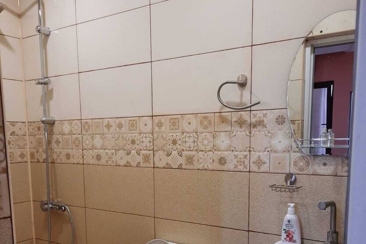 Une salle de bain équipée de toilettes, d’un lavabo, d’une douche et d’un miroir.