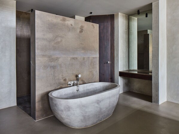 A modern bathroom with a freestanding bathtub, a large mirror, and a minimalist design.