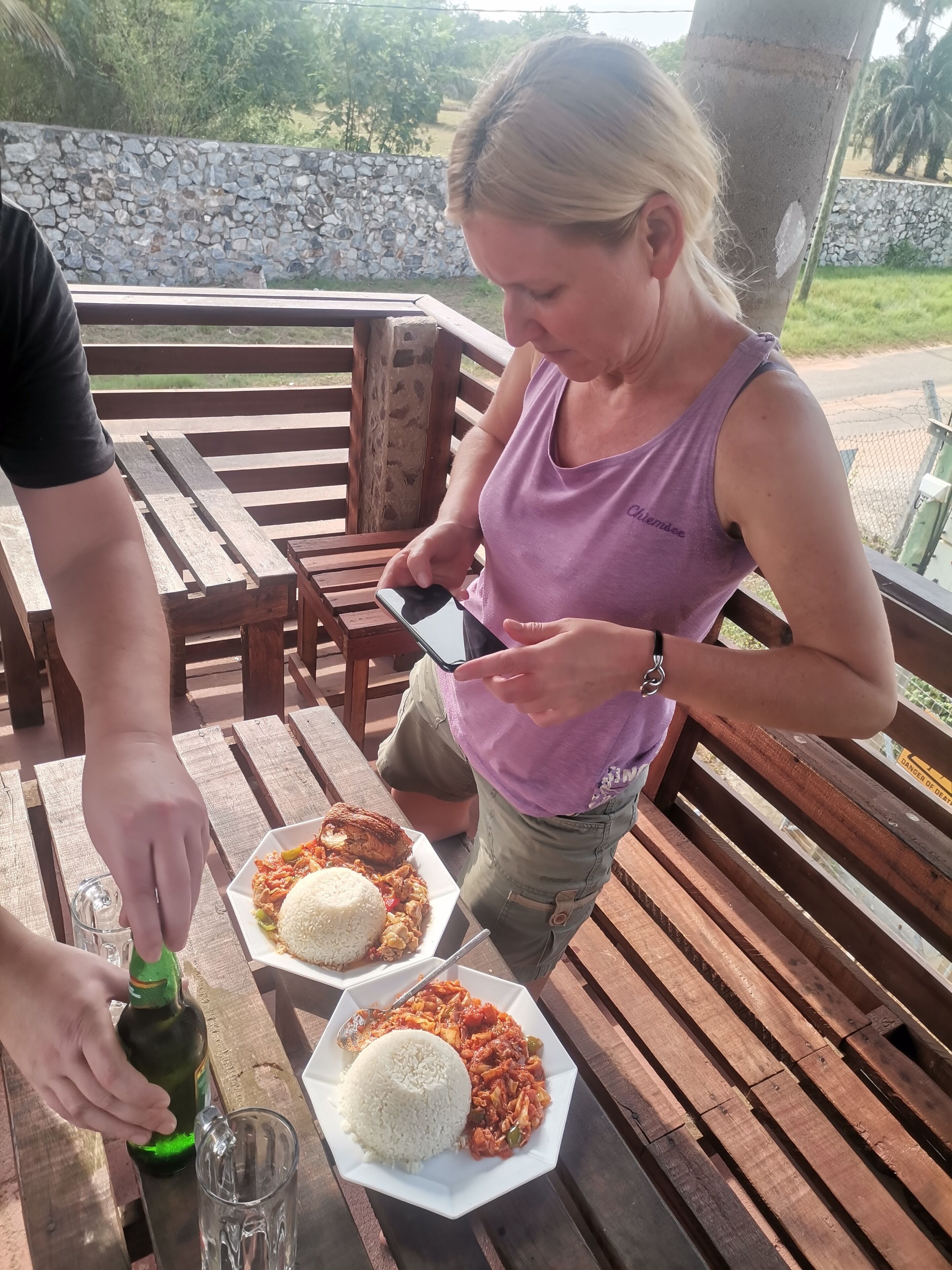 A person pouring a drink from a bottle onto a coaster.