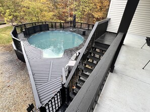 A hot tub on a wooden deck with a railing, surrounded by trees. - Majestic Ridge Lodge in Hocking Hills (Laurelville)