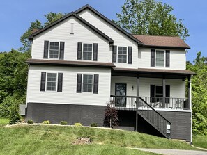 A two-story house with a front porch and a staircase leading to the second floor.