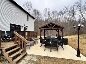 Une terrasse dotée de mobilier d’extérieur, d’un jacuzzi et d’une pergola avec éclairage.