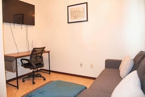 A room with a desk, chair, couch, and a framed picture on the wall. - 3BD 2BT Town Suite Minutes Away Medical Center (Edinburg)