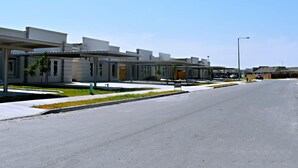 Un edificio moderno con una galería techada y estacionamiento.