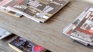 A wooden table with several magazines, including 'New Orleans' and 'Saints'. - Beautiful Downtown Condo "Unbeatable Location" with Secure Onsite Parking (New Orleans)