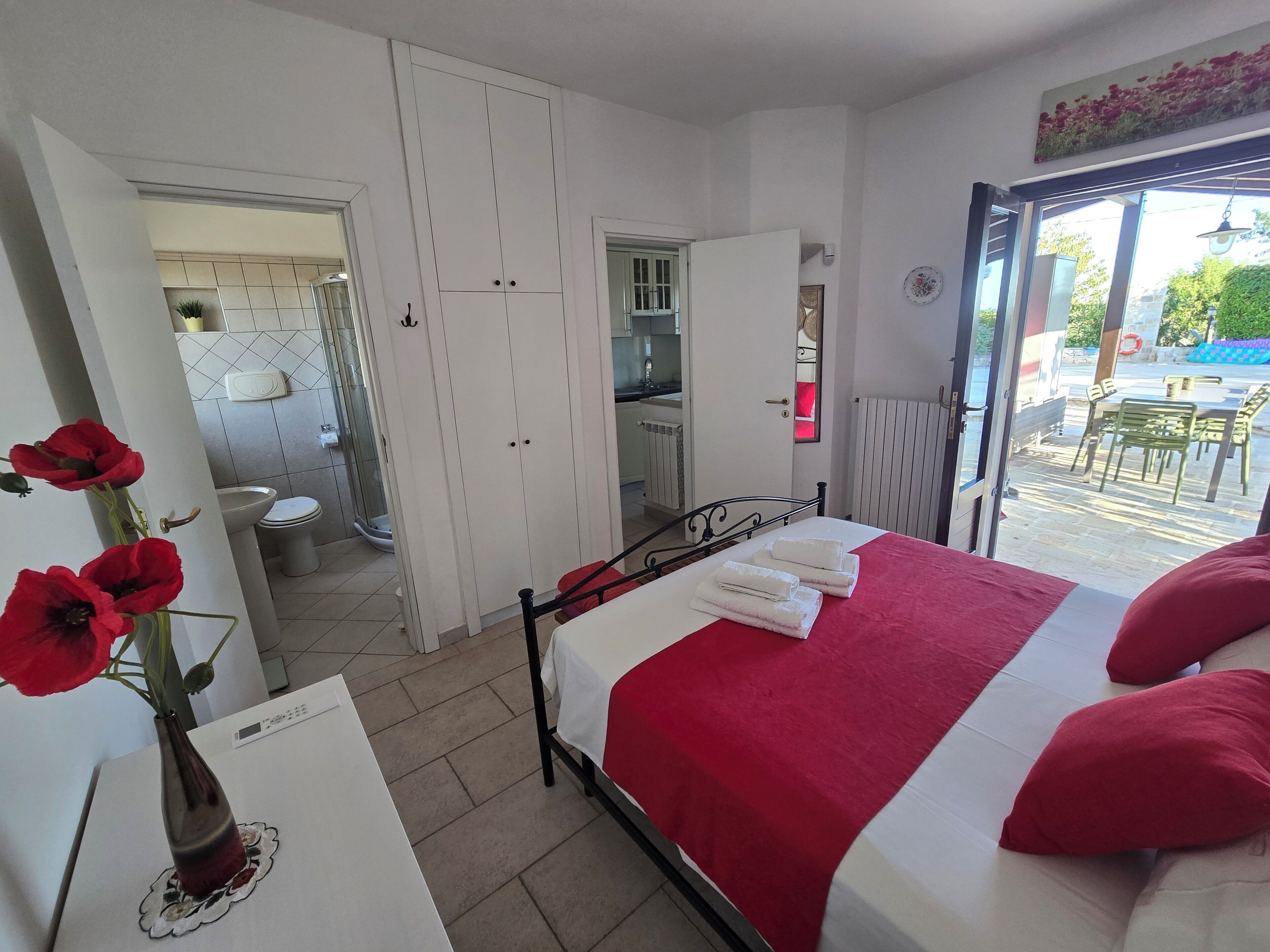 Un dormitorio con cama, baño y vistas al exterior.