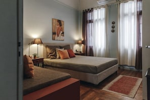A bedroom with a double bed, two bedside tables, a nightstand, a lamp, a painting on the wall, and a window with curtains. - Monastiraki-Psiri, Old Town, 3-bdr apt, sleep 6-10p, spacious court yard (Athina)