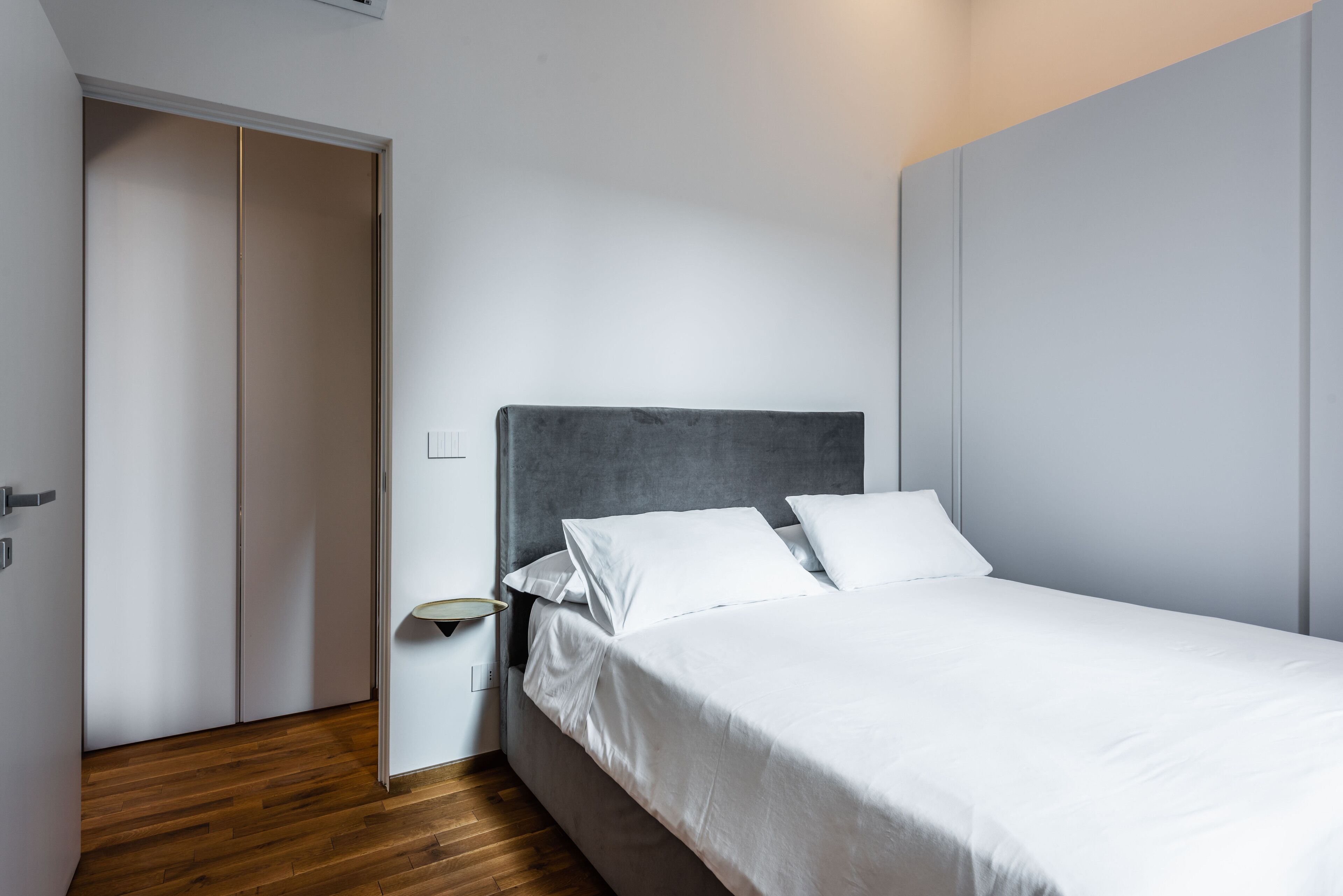 Un dormitorio con cama, mesita de noche y armario.