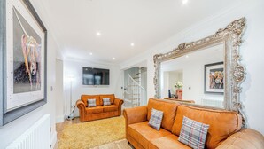 A living room with two sofas, a large mirror, and artwork on the walls.