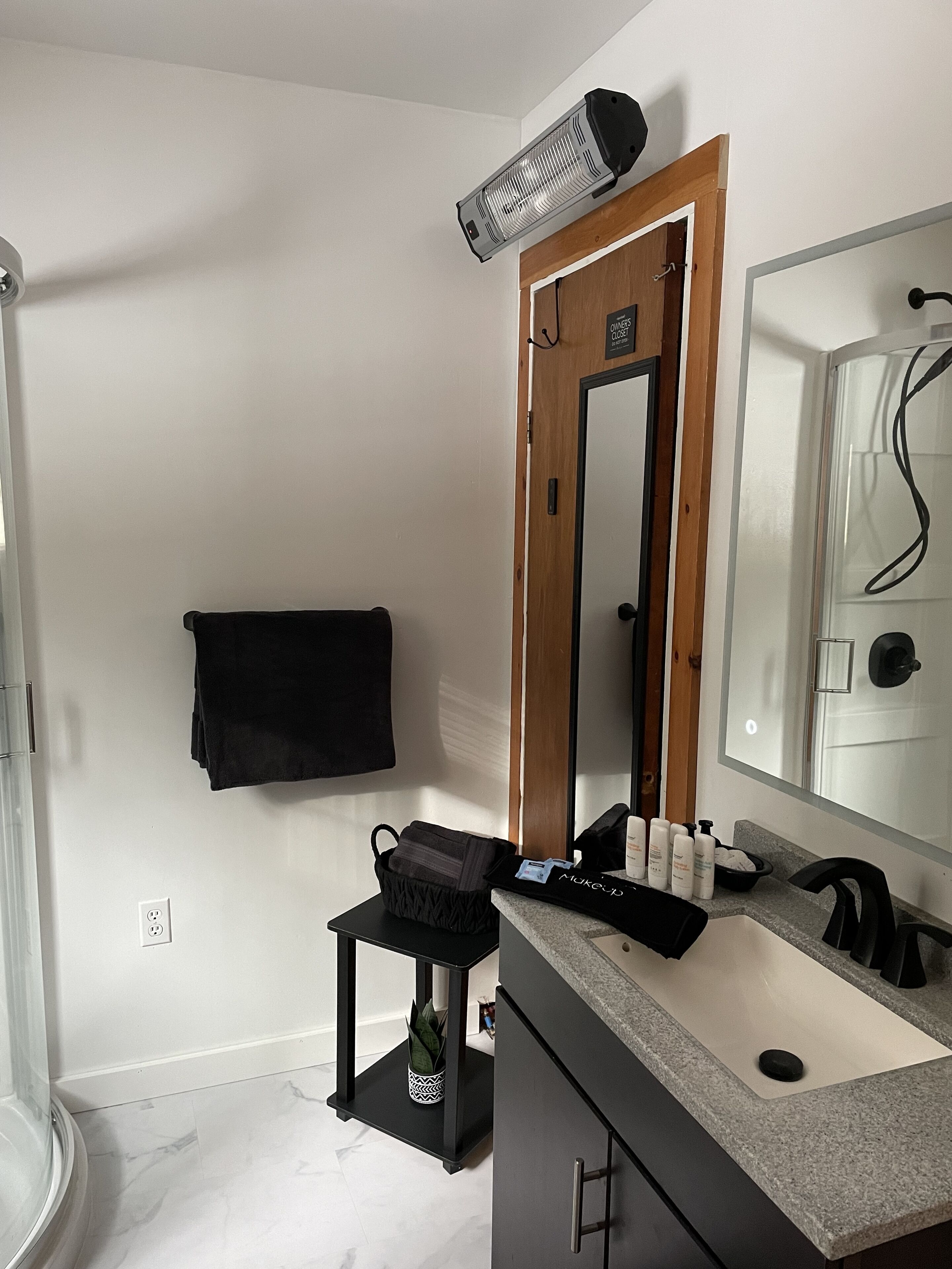 Une salle de bain équipée d’un lavabo, d’un miroir, d’un porte-serviettes et d’un radiateur.