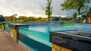 Una piscina con un muro de piedra y una cubierta de madera.