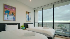 A hotel room with two beds, large windows, and posters on the wall. - Pokemon Inspired Apt -Pool-Gym-Sauna-Steam Room (Adelaide)