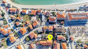 Vista aerea di una zona residenziale costiera con case, una spiaggia e una posizione contrassegnata.