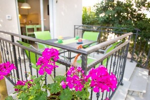Enjoy a meal on the balcony overlooking the dining area with a table and chairs.