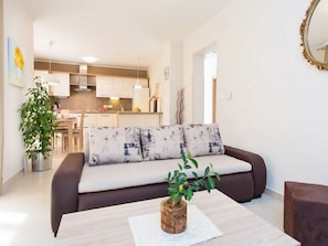 Uma sala de estar moderna com um sofá marrom, uma mesa de centro e um vaso de planta.