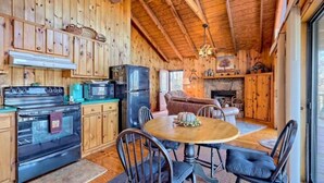 L’intérieur d’une cabane en bois comprend une cuisine, un coin repas et un salon.